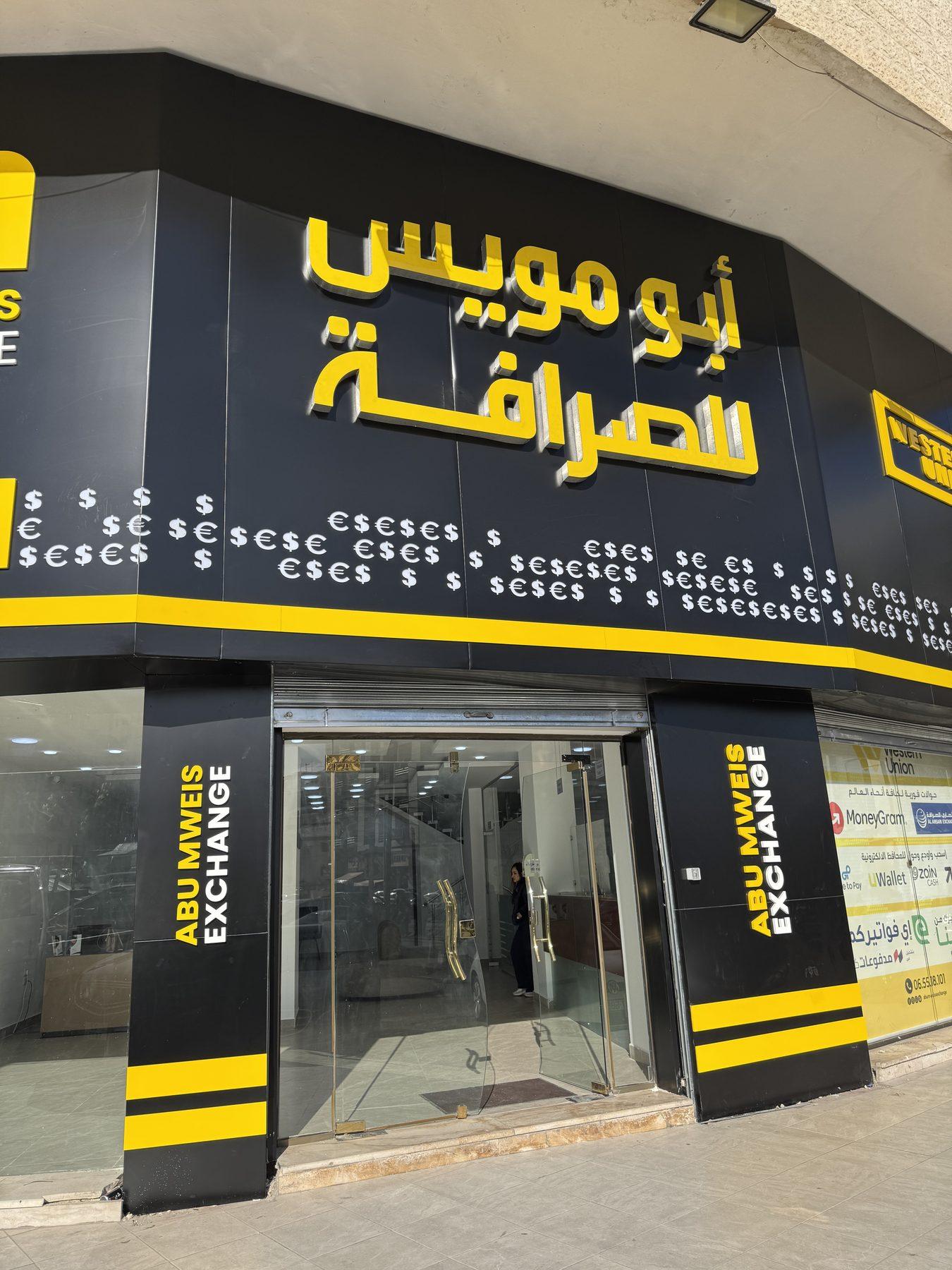 The Arabic name above the entrance and the currency-symbol band.