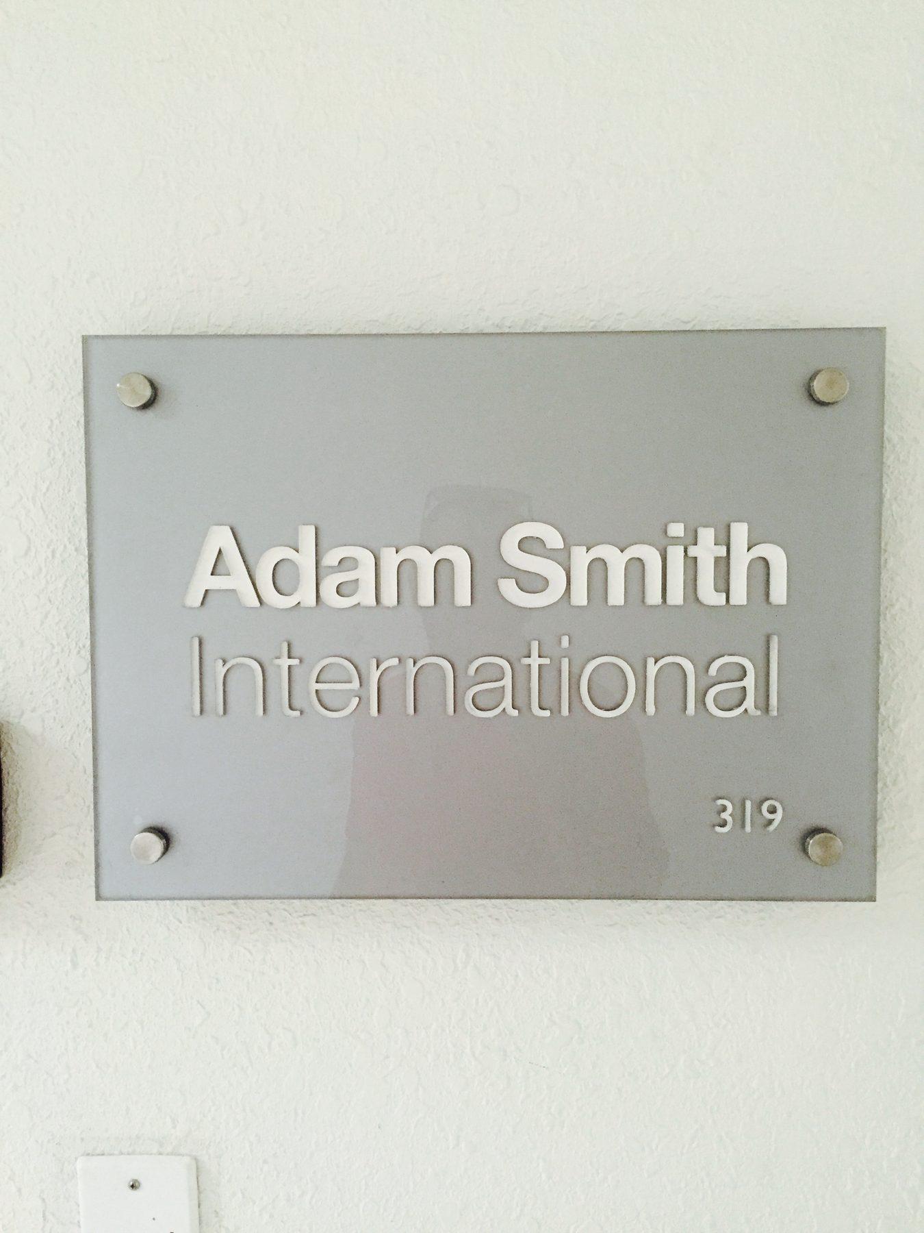 Brushed acrylic wall plaque with the company name and a suite number.