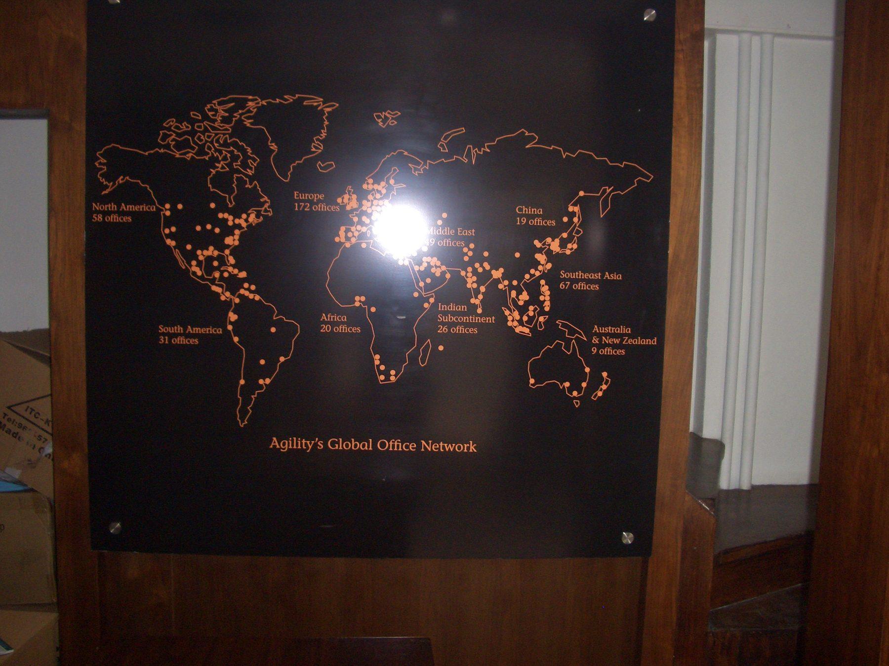 Dark wall panel with a printed world map and office network text