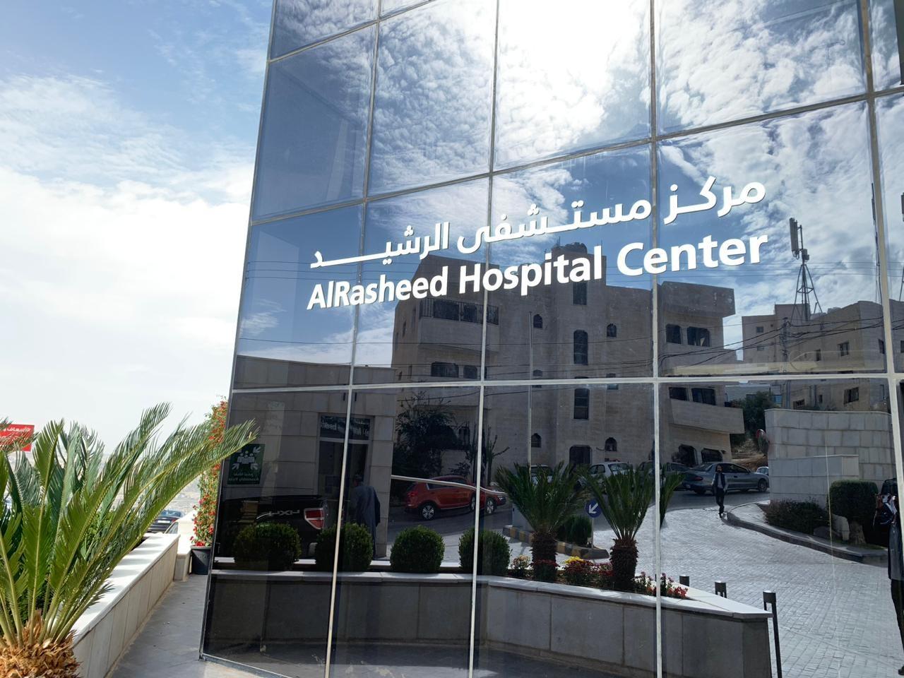 Lettering on a glass facade reflecting the surrounding buildings