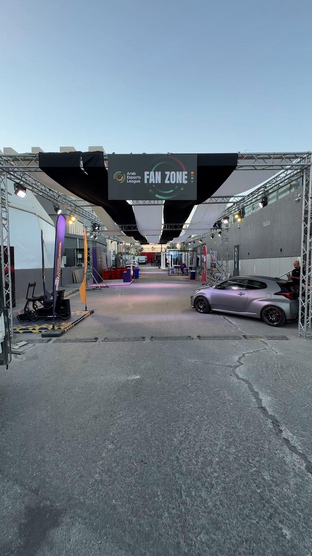 The fan-zone street under a truss arch with the league banner.