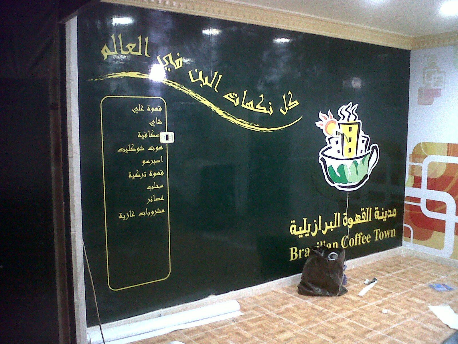 Dark cafe wall graphic with gold lettering and a logo