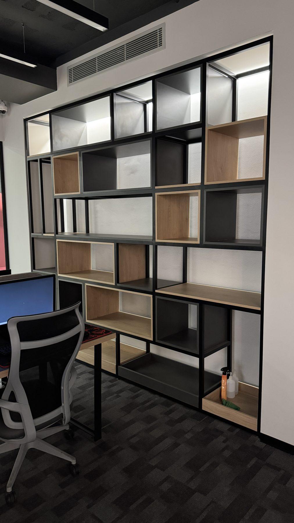 The steel-and-wood shelving wall.