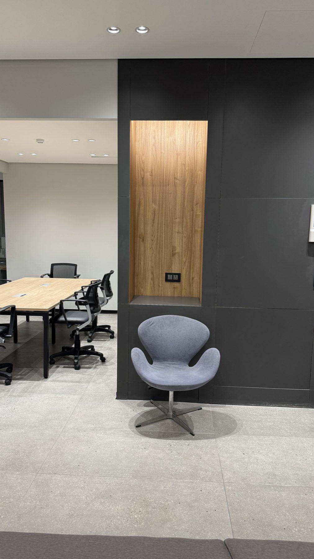 A meeting area beside a wood-veneer niche.