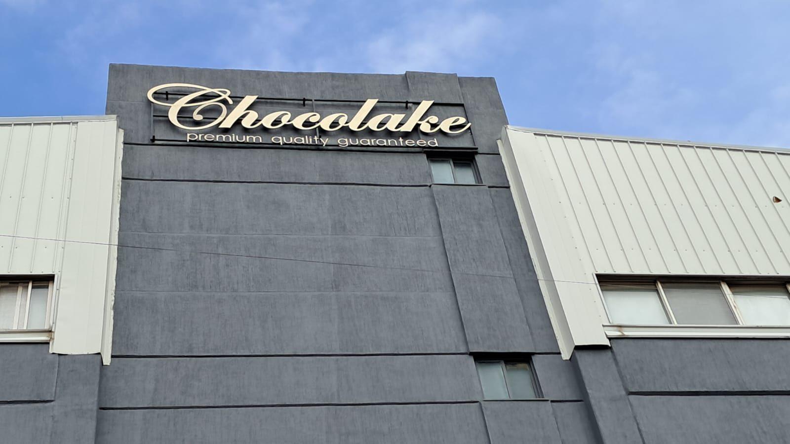 Lettering on the upper facade of a grey building against a blue sky