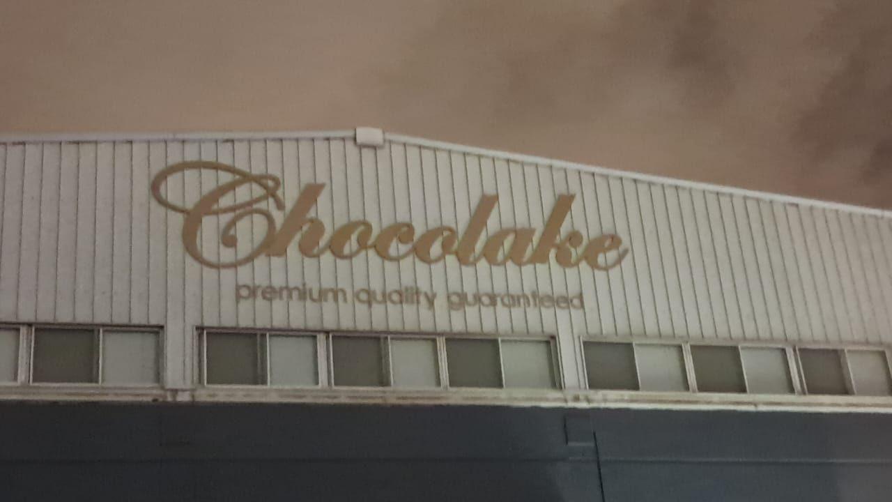 Gold script lettering with tagline on a light building facade