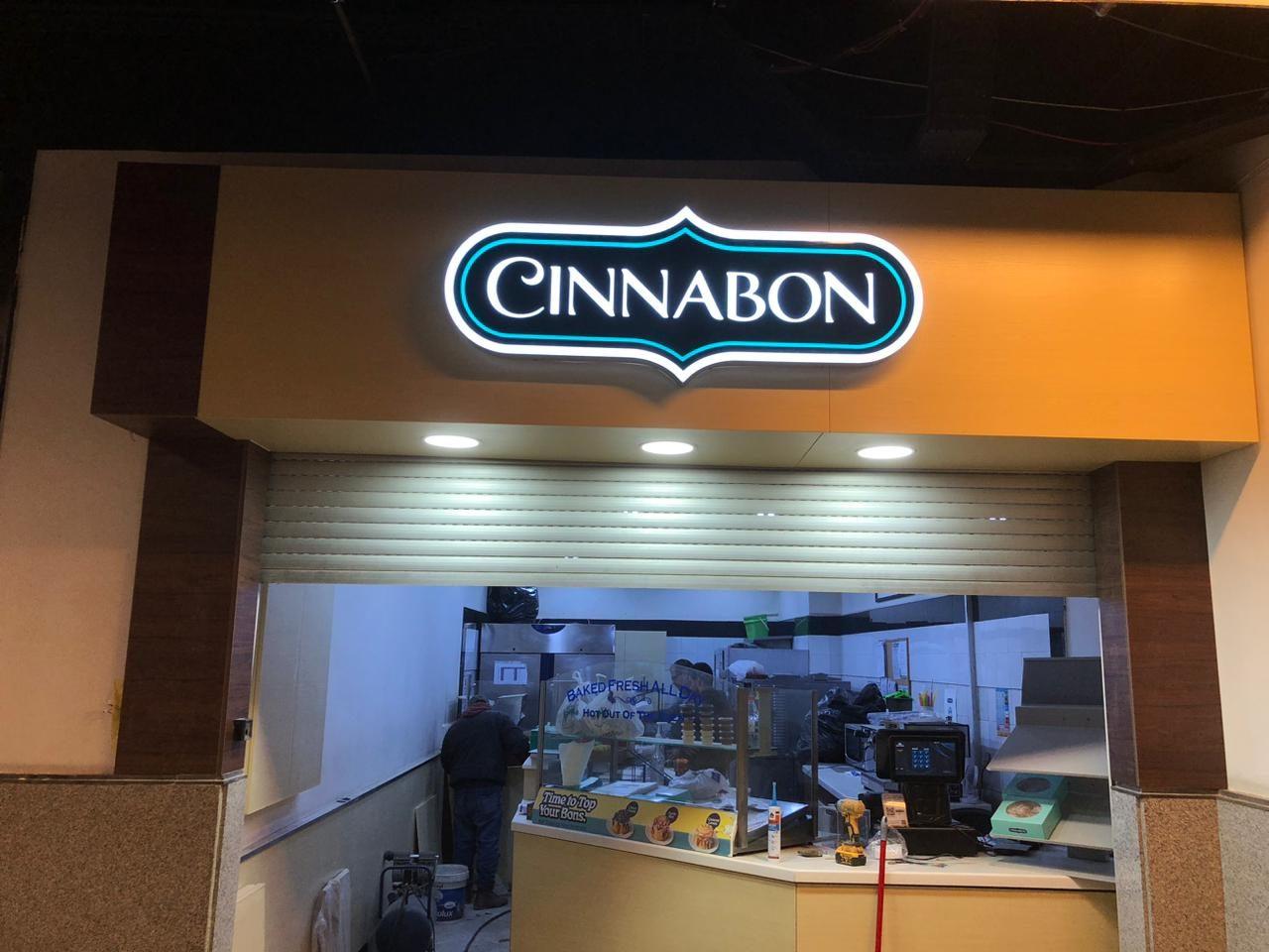 Illuminated logo sign over a bakery counter
