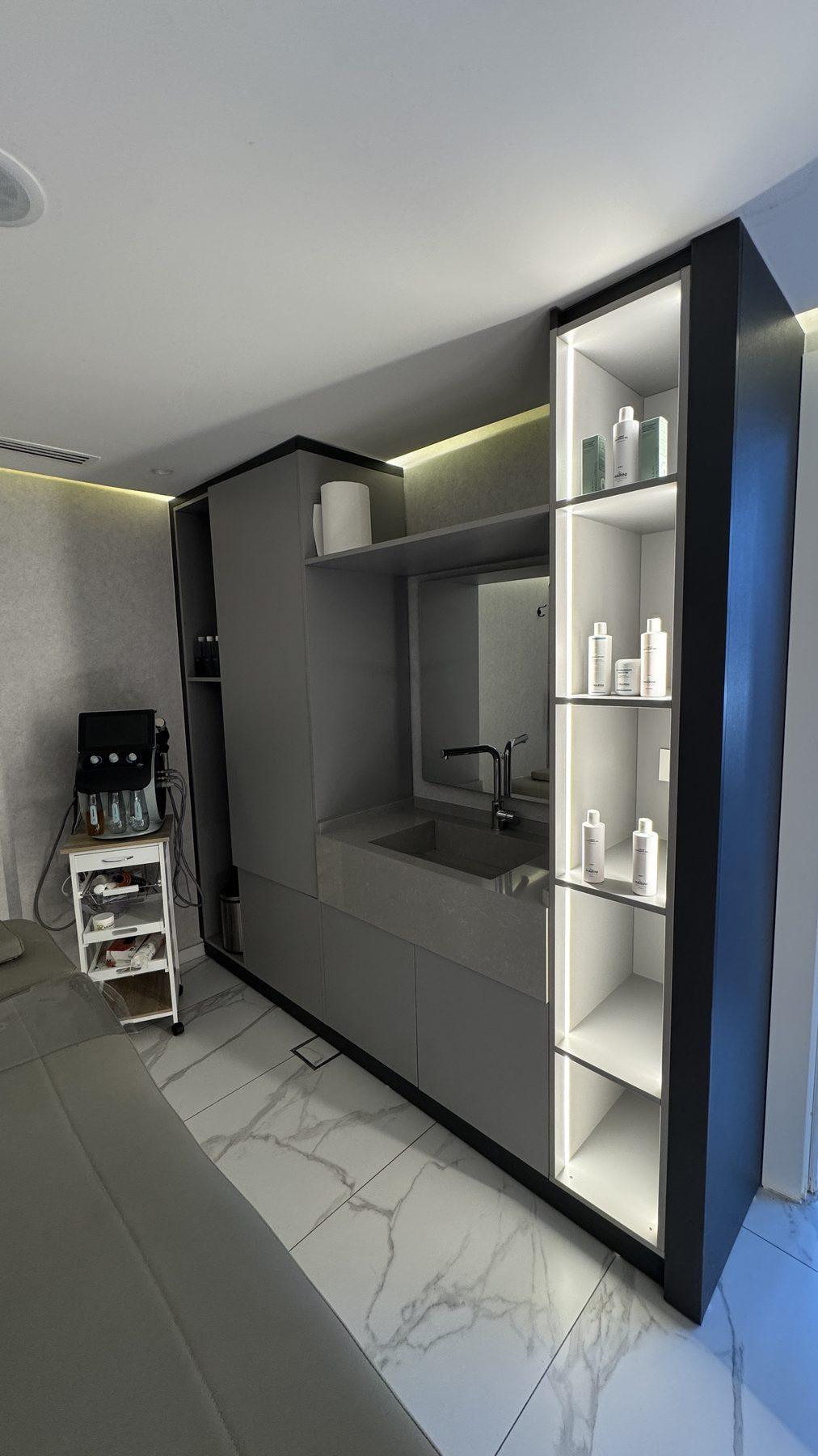 A treatment room with lit shelving.