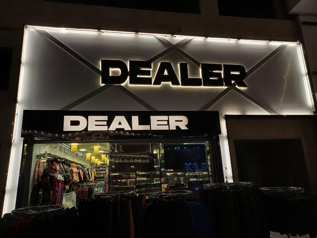 Illuminated fascia with a backlit panel and dark raised lettering at night.