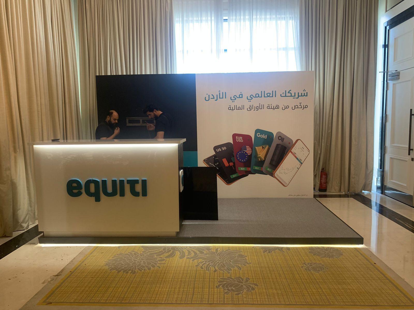 Backlit logo on a reception counter in front of a printed backdrop