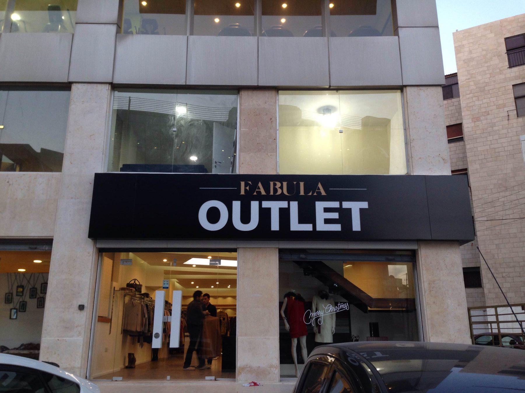 Dark fascia with white lettering over a shopfront, in daylight
