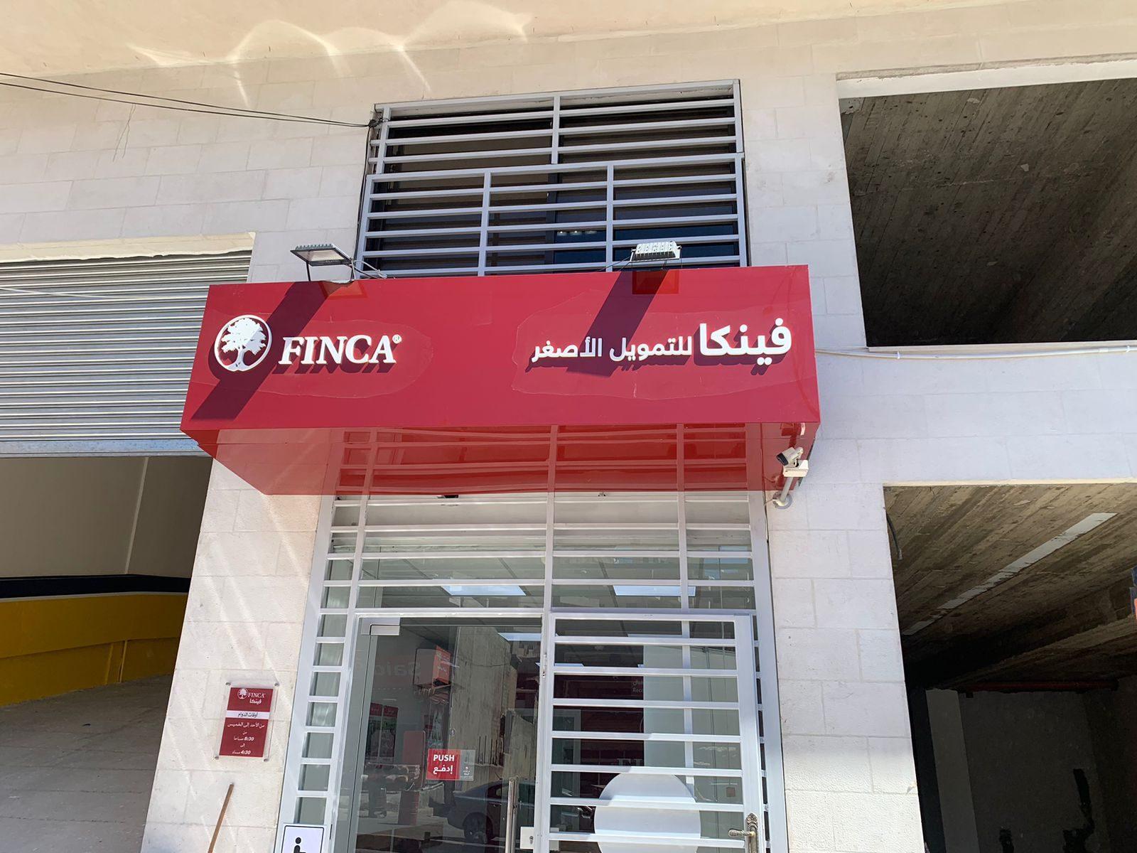 Red fascia sign above a shopfront in daylight