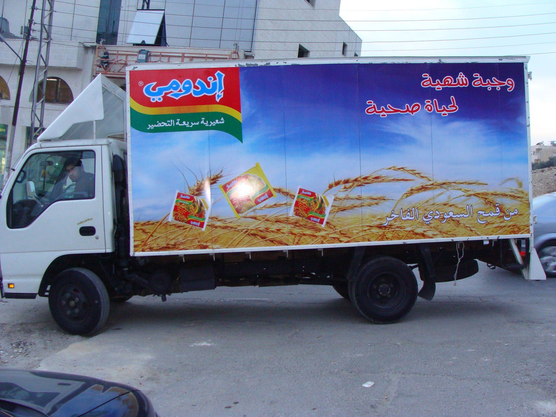 Box truck side with product packs and wheat-field graphic