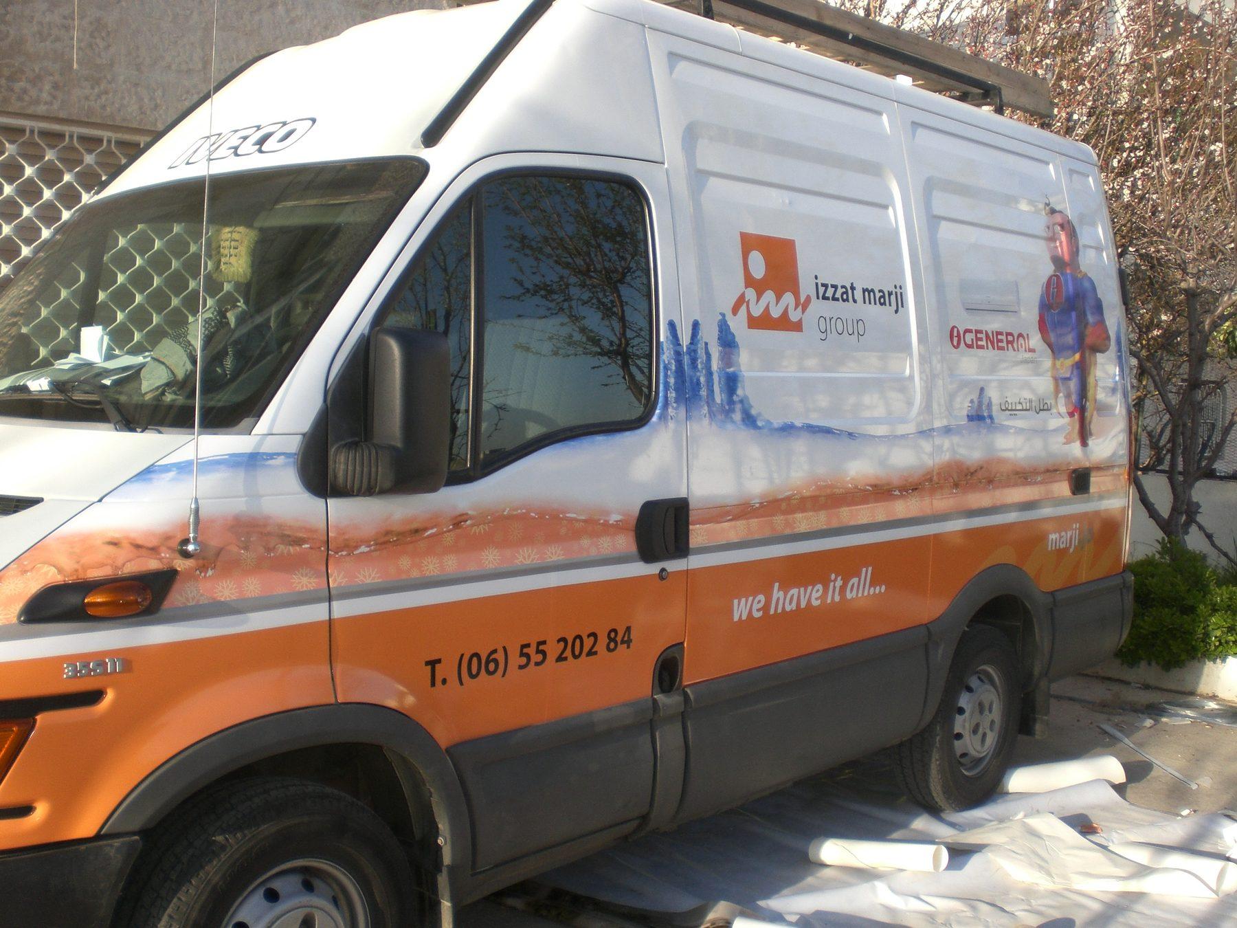 White van with orange graphics, logo and product photos along its side