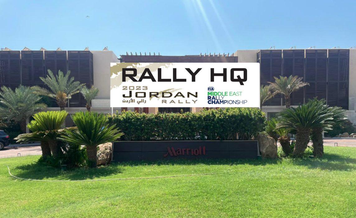 Headquarters sign board on a wall in front of palm trees