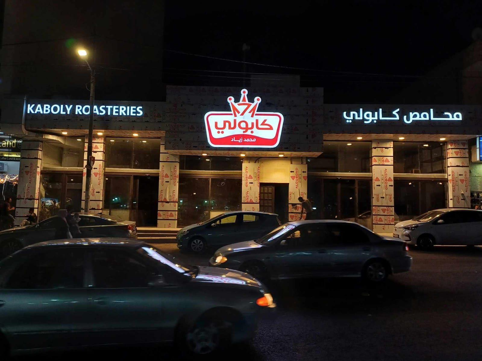 Illuminated fascia at night with the shopfront lit below