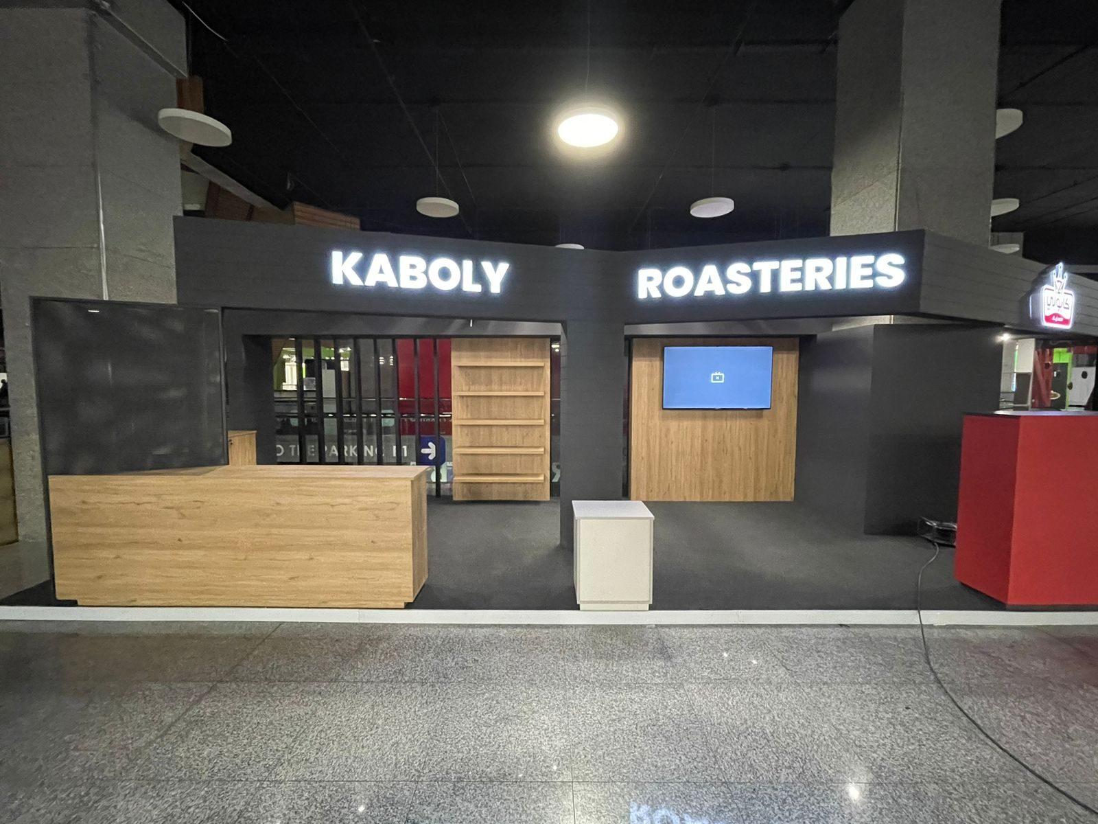 Mall booth with illuminated lettering and wood counter