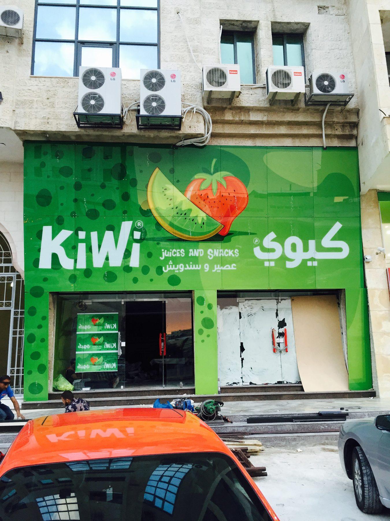 Green storefront graphics with a juice logo