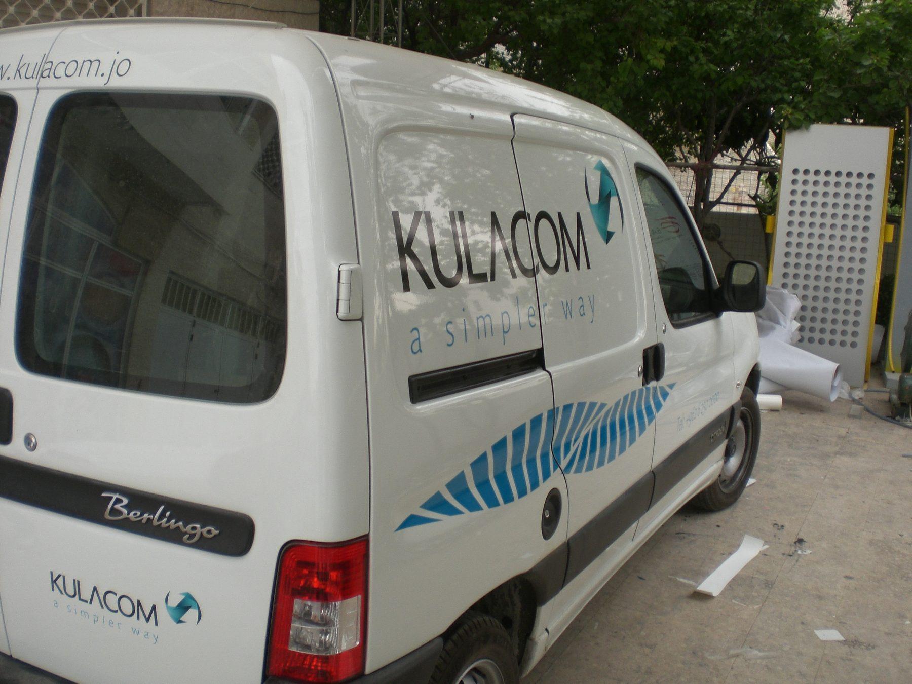 Rear three-quarter view of a white van with logo and wave stripe