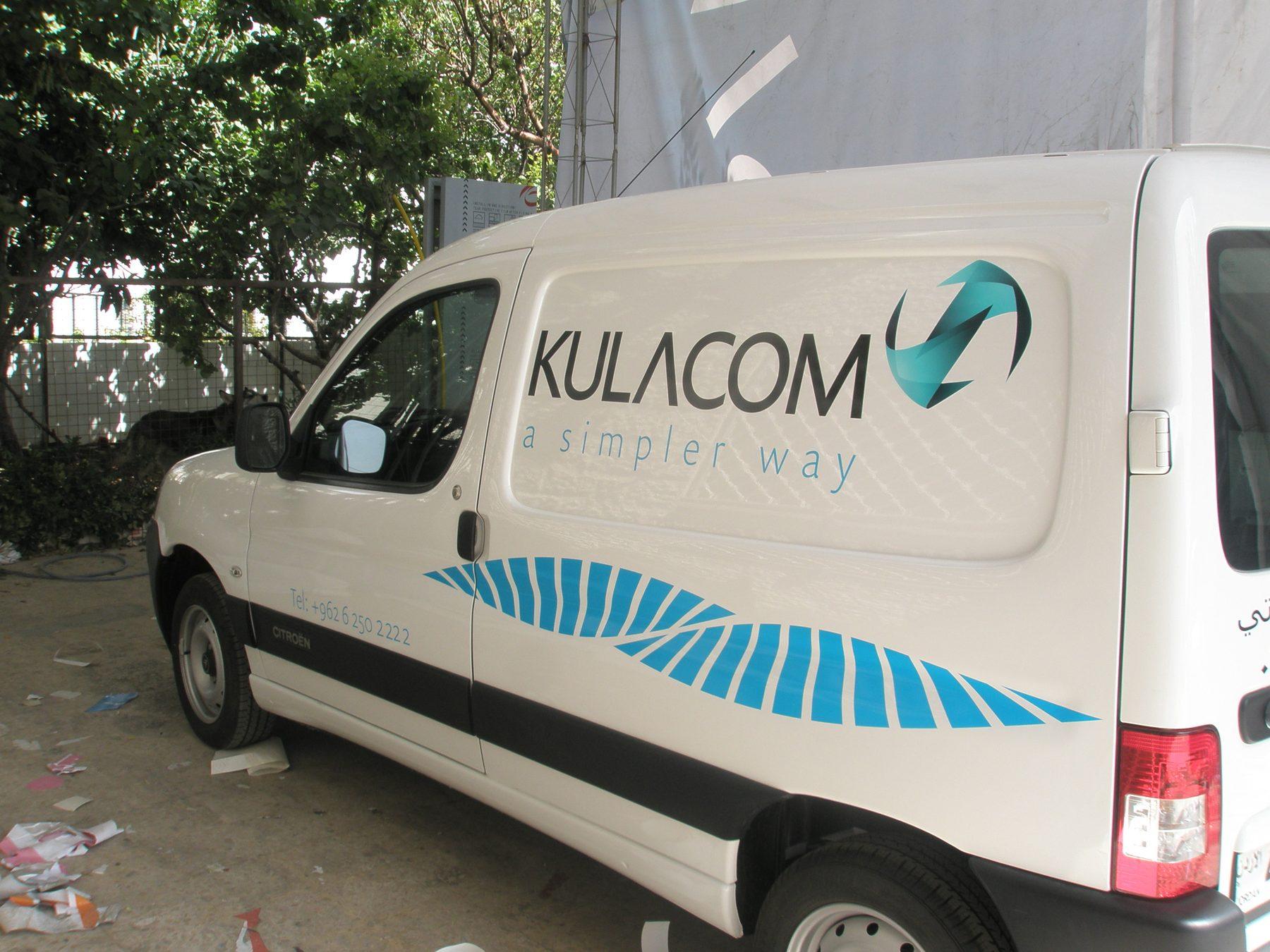 Three-quarter side view of a white van with logo and wave stripe