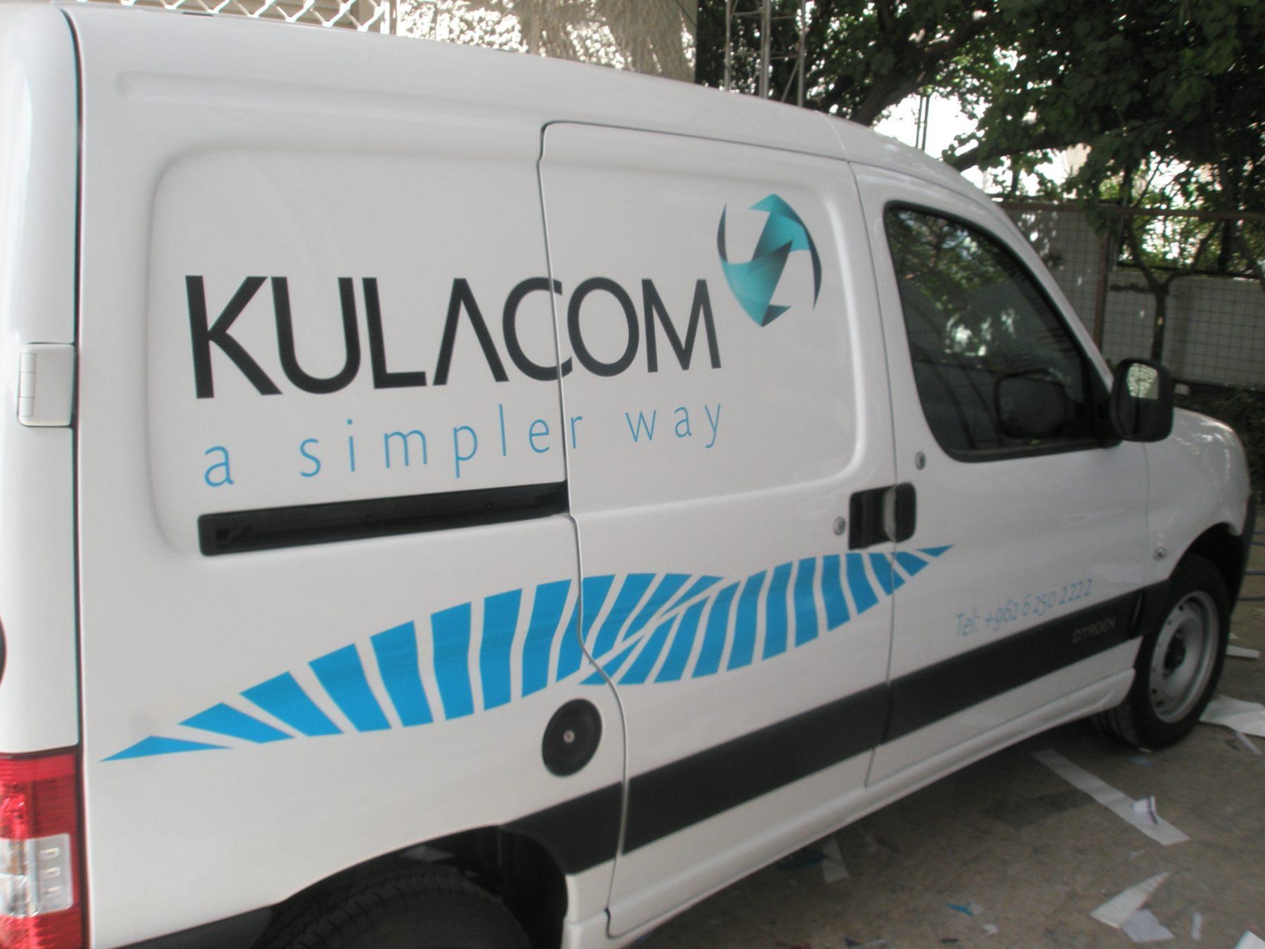 Side view of a white van with logo and blue wave stripe