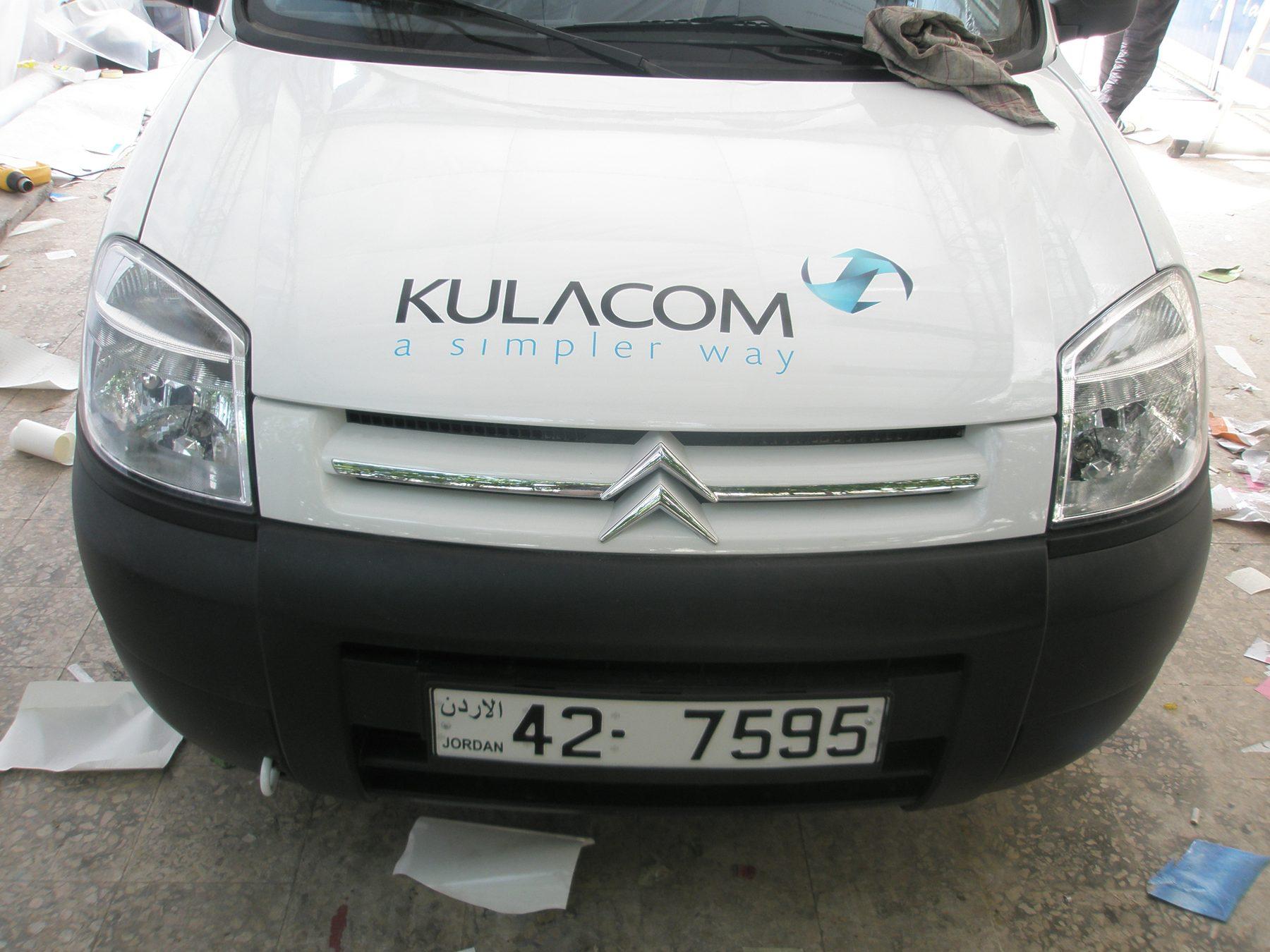 Front of a white van with logo above the grille