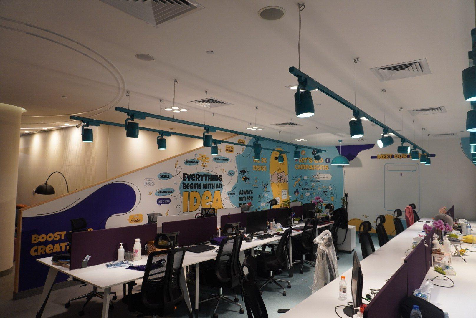 An office interior with printed wall graphics above tables and seating.