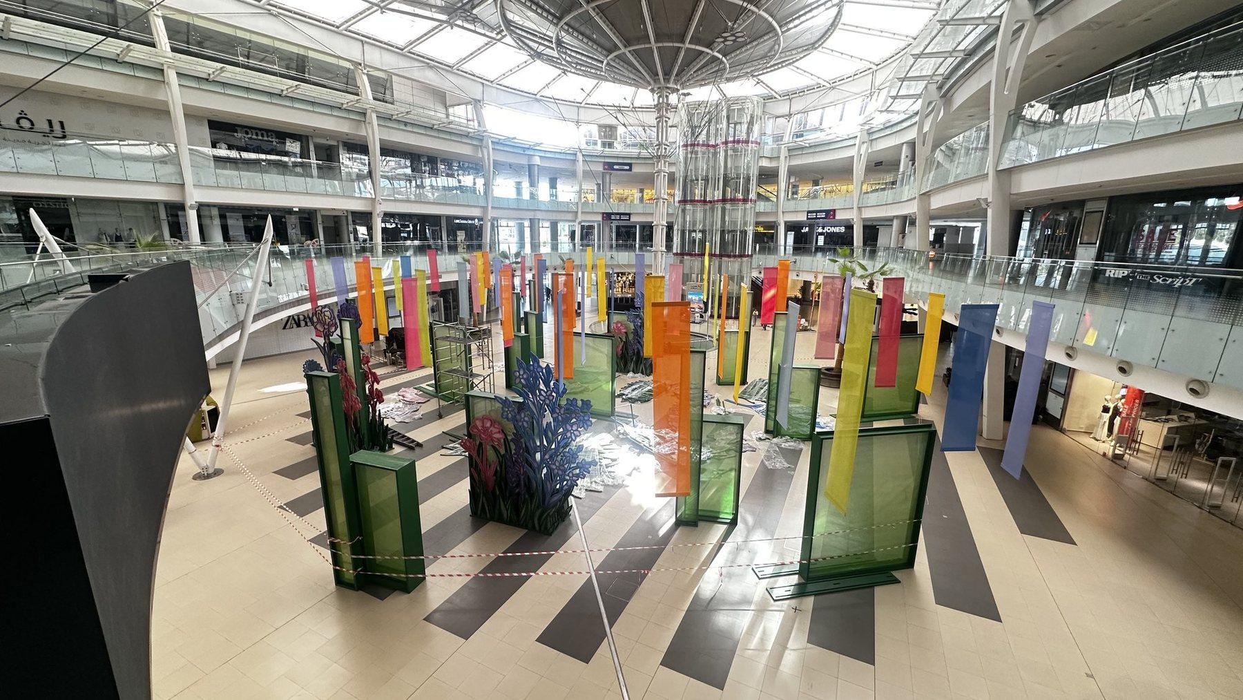 Wide view of the atrium installation with colourful panels and plant displays.