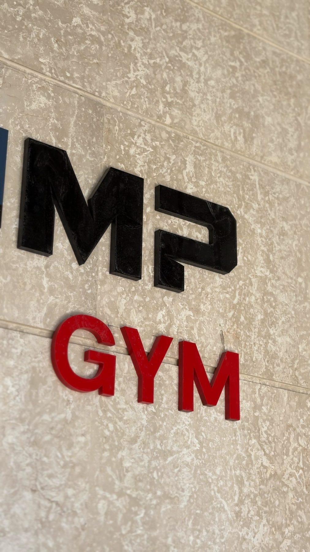 Raised Max Pump Gym lettering on a stone-effect wall.