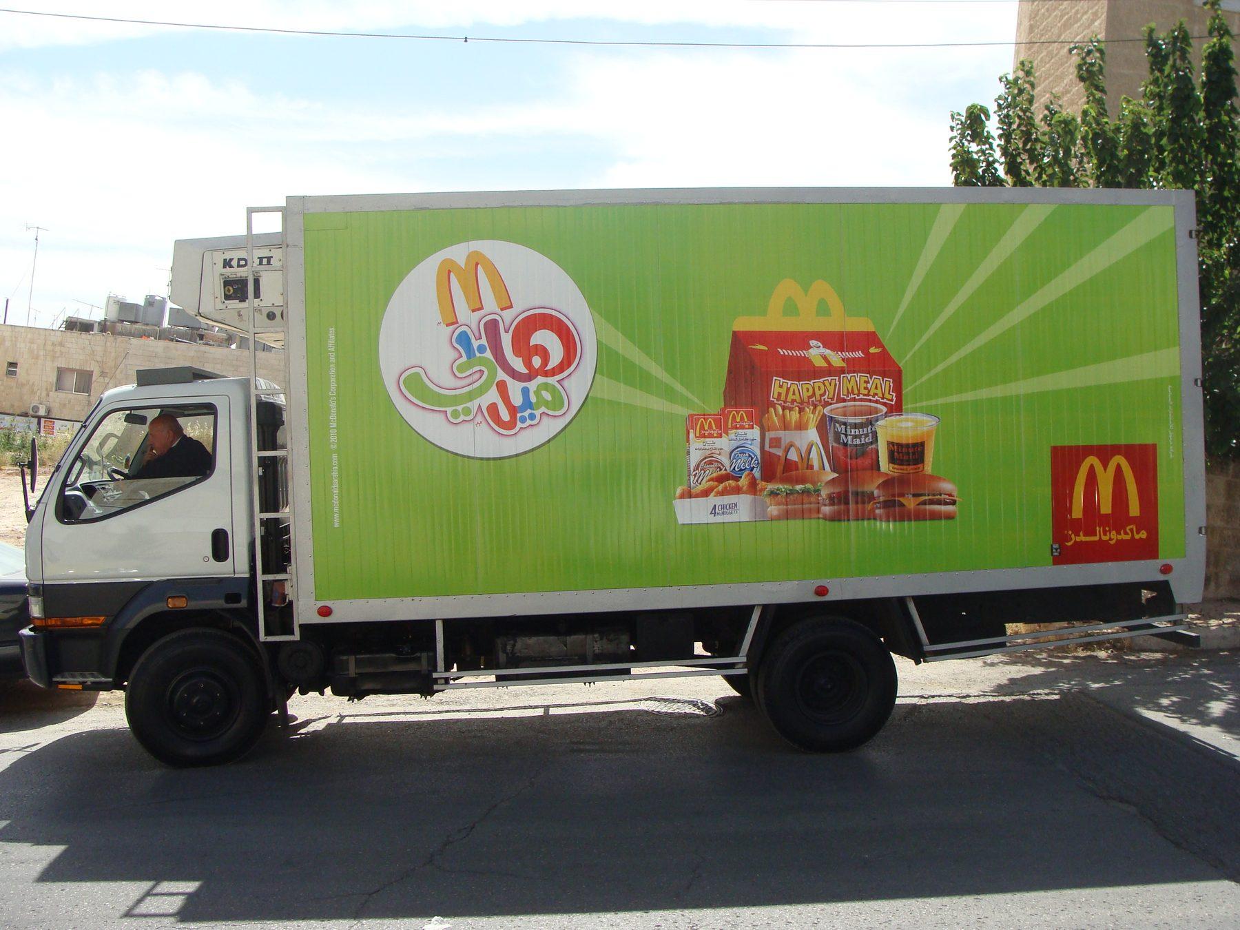 Green box truck side with sunburst and product imagery