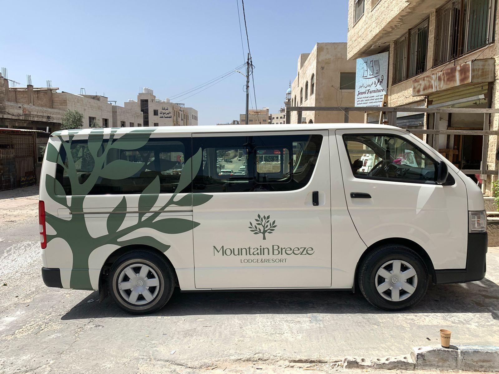 Green leaf graphic and logo on a white passenger van
