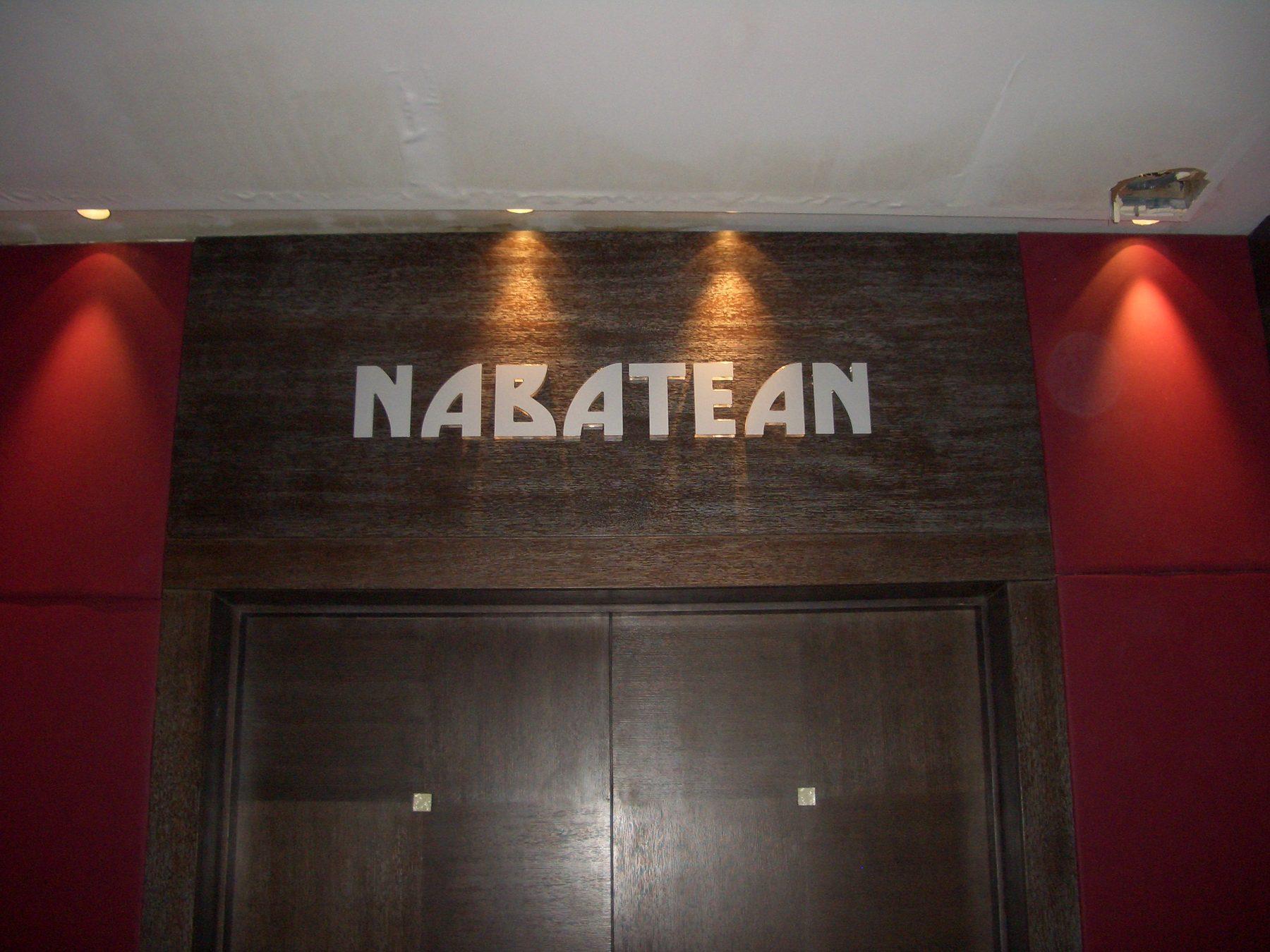 Dimensional lettering on a dark wall between uplit panels