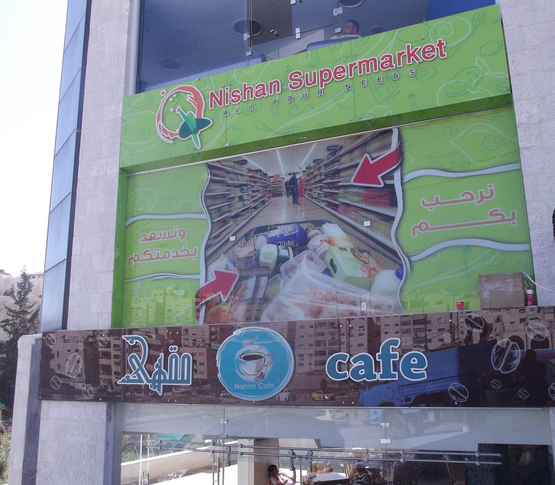 Printed green facade panel with shop imagery