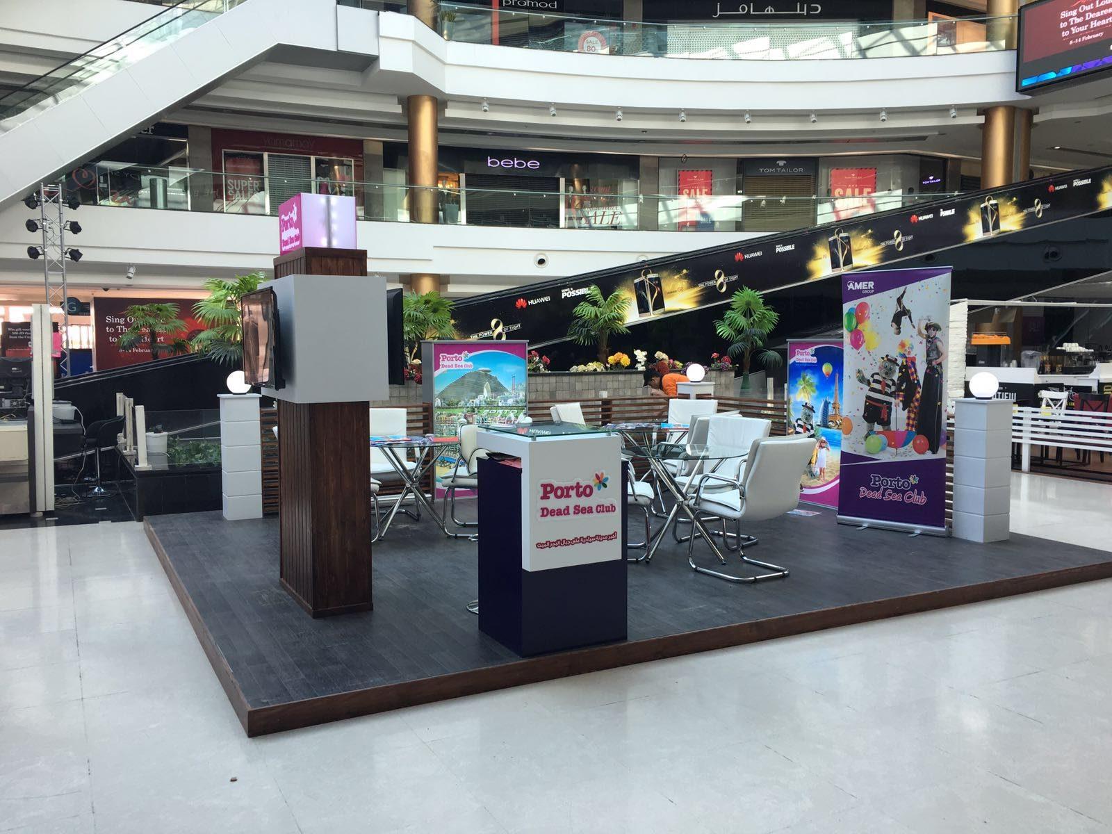 Booth with white and dark-blue counters and seating in a mall atrium
