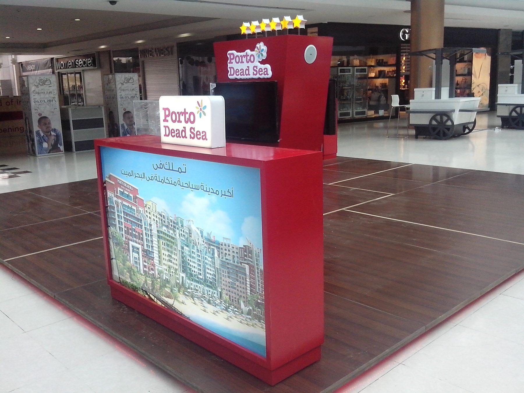 Red-based booth with backlit image panel in a mall