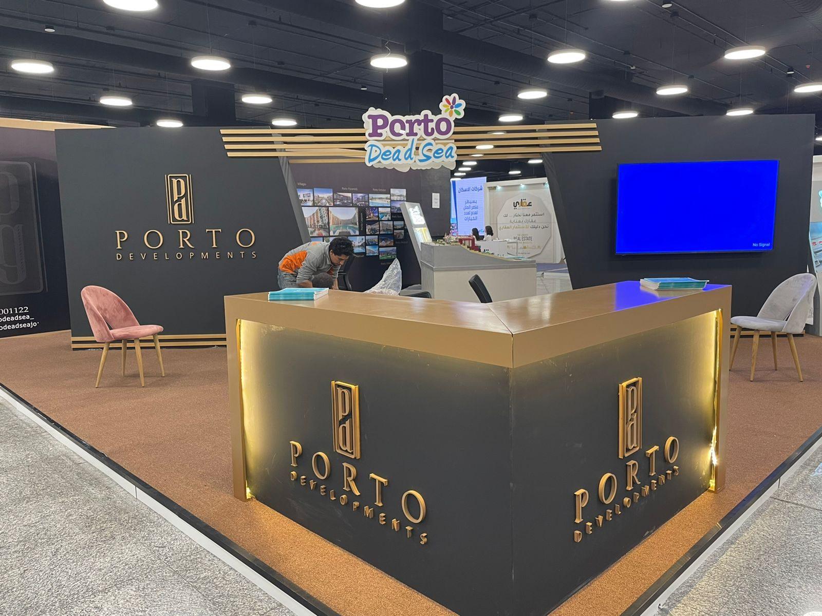 Black-walled booth with gold-lit counter and wall screen