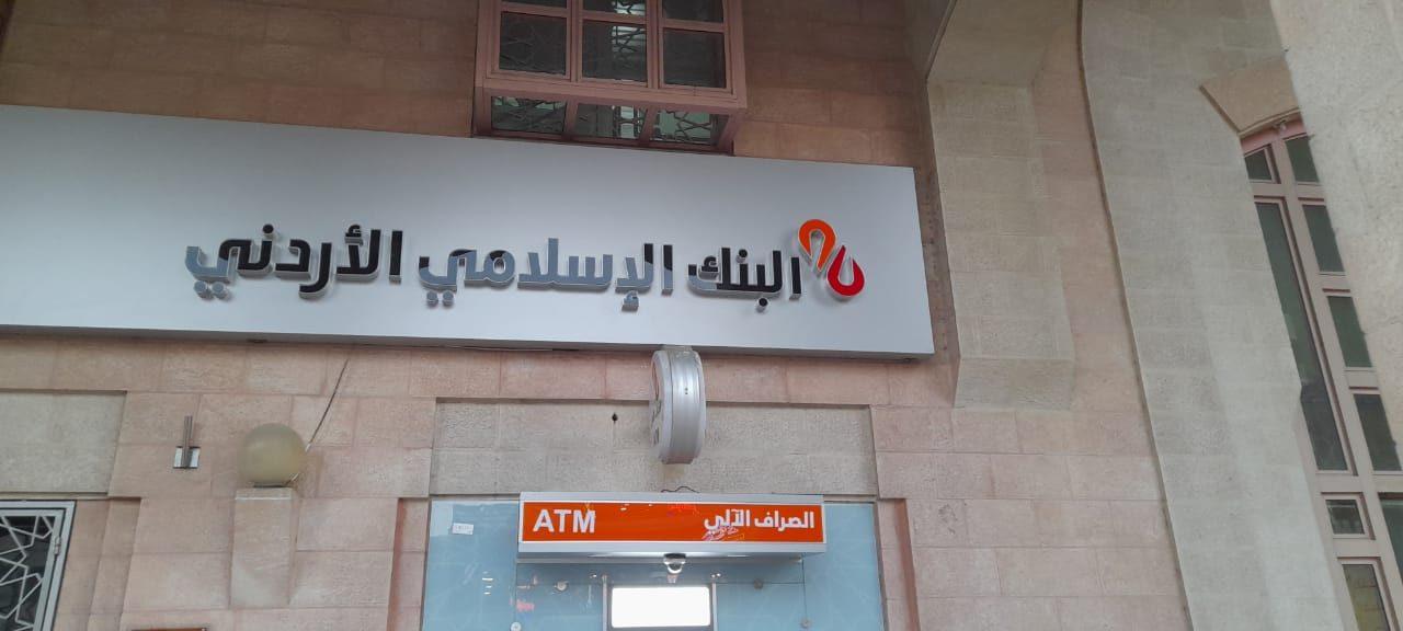 Fascia with logo and Arabic name above a branded ATM bay