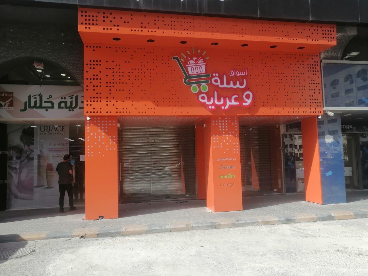 Perforated orange facade with the brand logo over a shop front