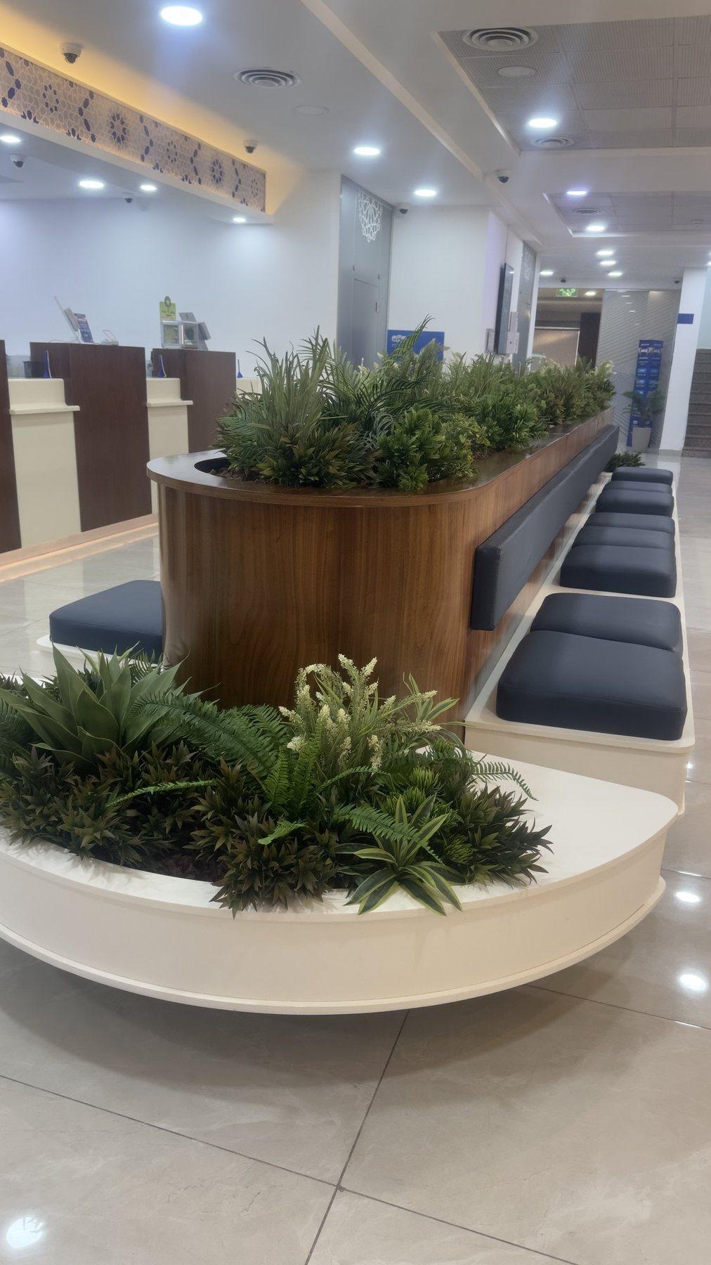 Waiting area with a curved white planter bench and navy cushioned seats.