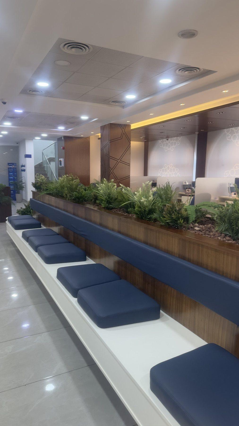 Long planter bench with navy cushioned seating in a bright lounge.