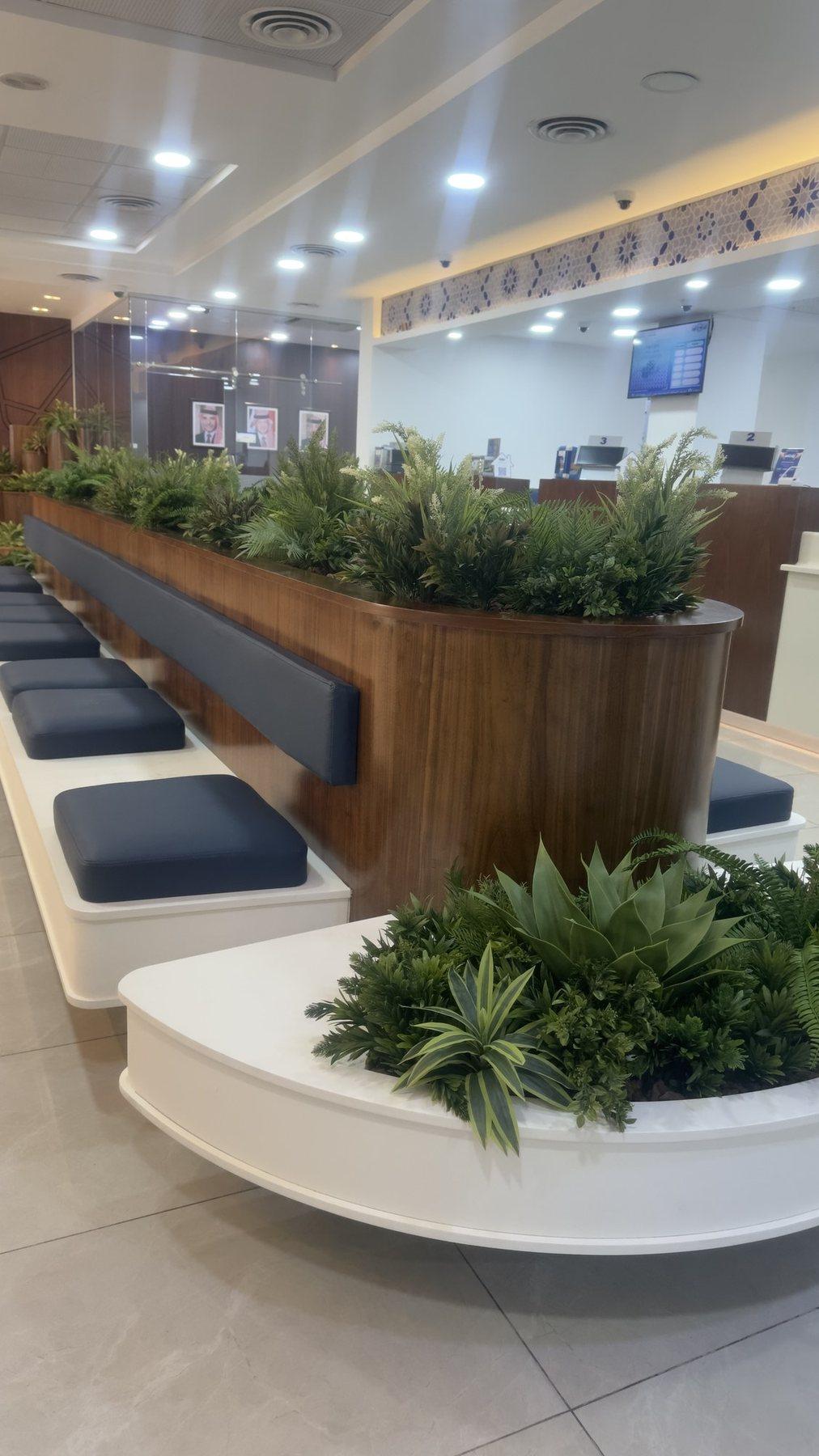 Curved planter bench and navy seating in a bright lounge with ceiling lights.