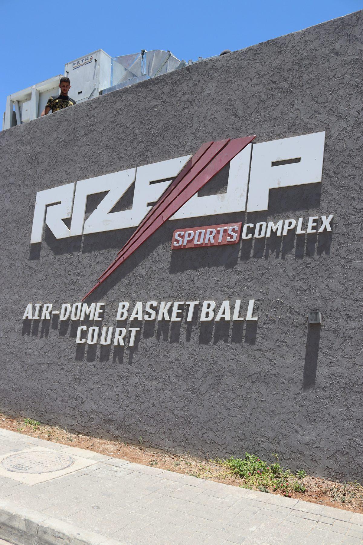 The RizeUp Sports Complex logo and air-dome basketball court sign on the outside wall.