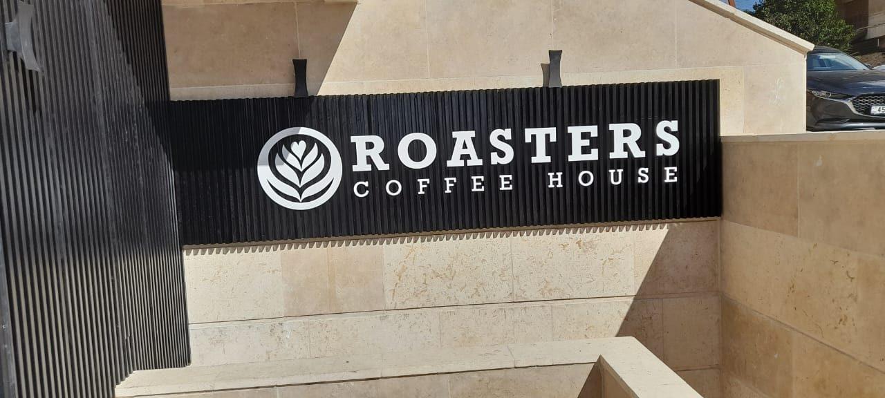 Dark fascia with logo on a stone-clad wall