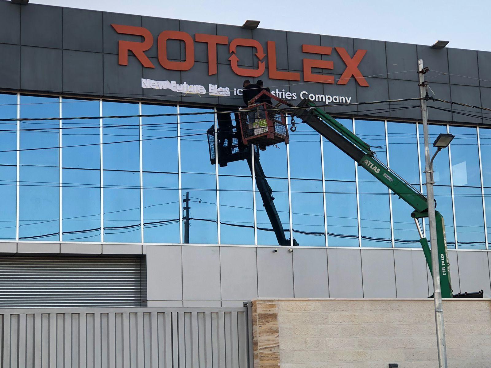 Lift working on the sign on a building front in daylight
