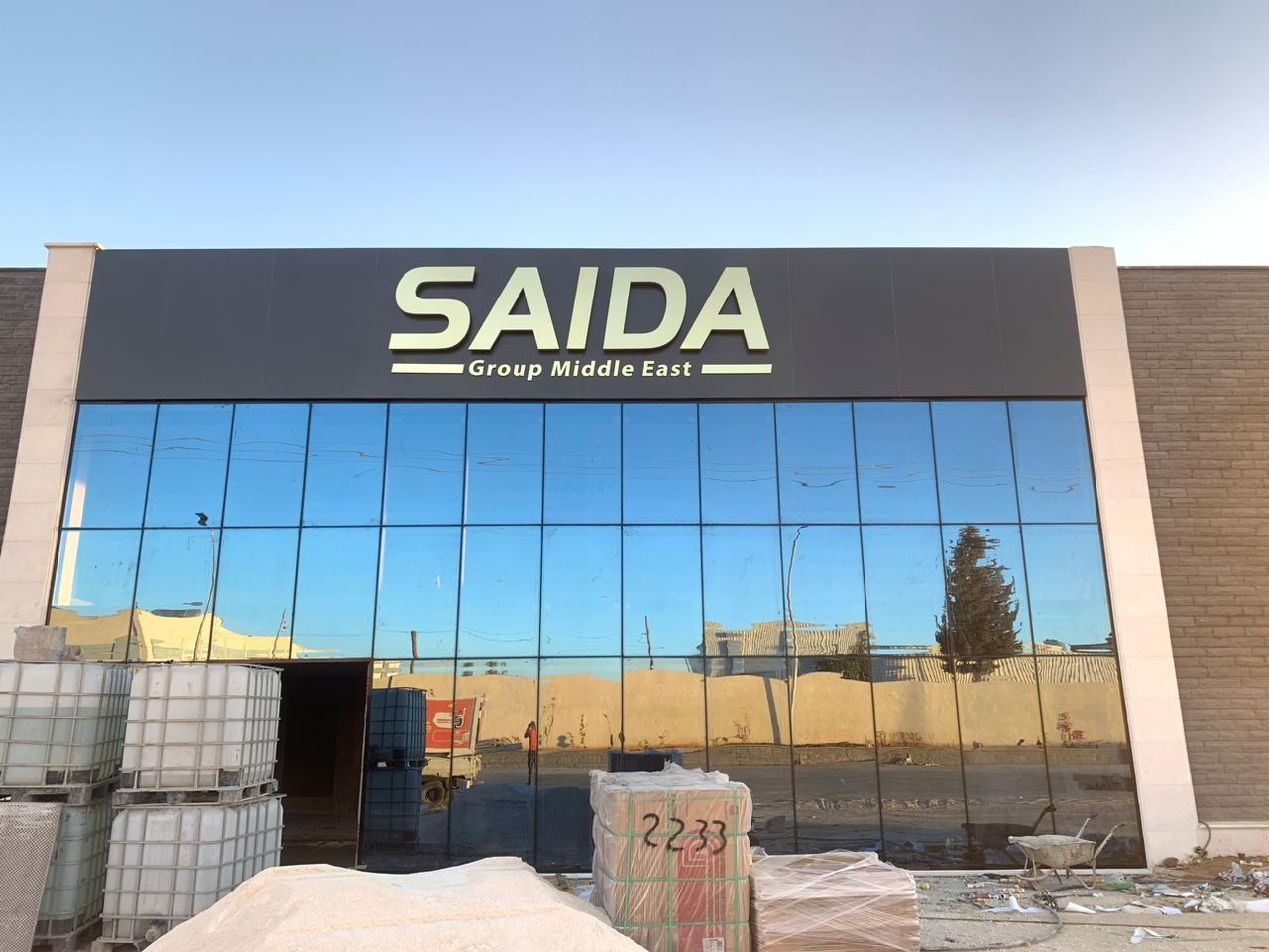 Dark aluminium fascia with raised lettering over a glazed building