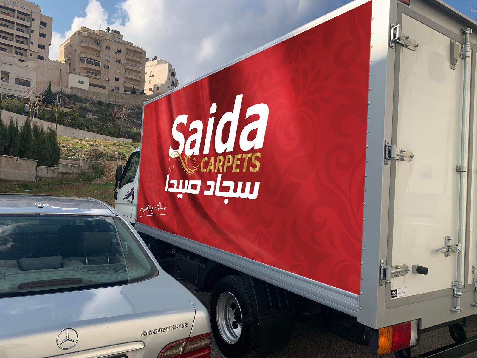 Box truck with a red carpet wrap, front three-quarter view