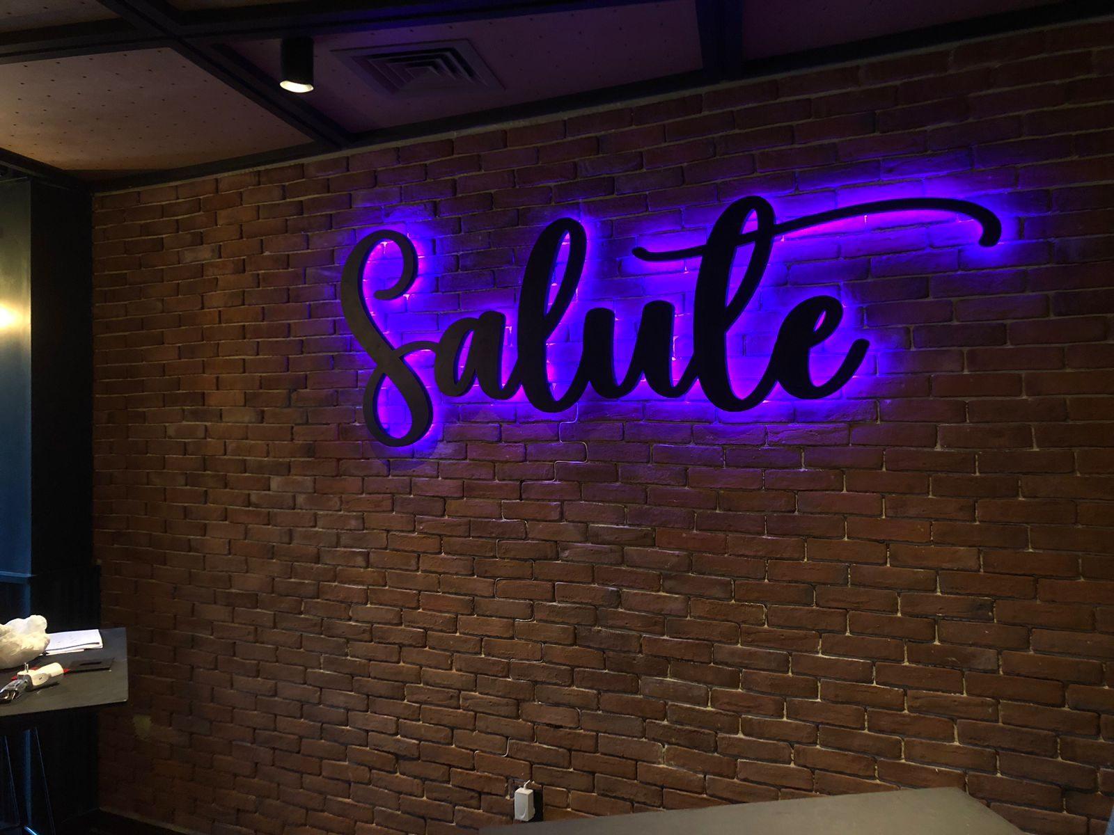 Halo-lit script lettering on a brick wall
