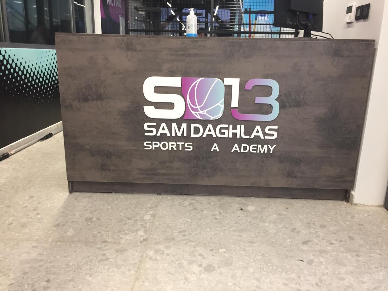 Logo and name on a dark reception desk front