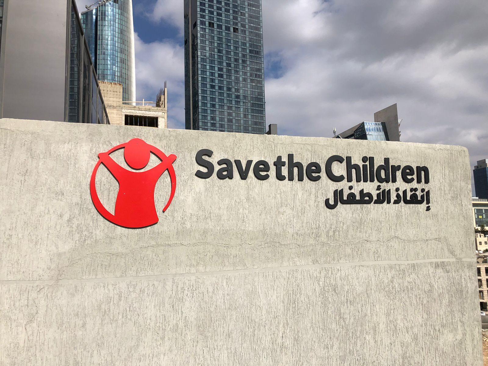 Dimensional logo and bilingual wordmark on a concrete wall