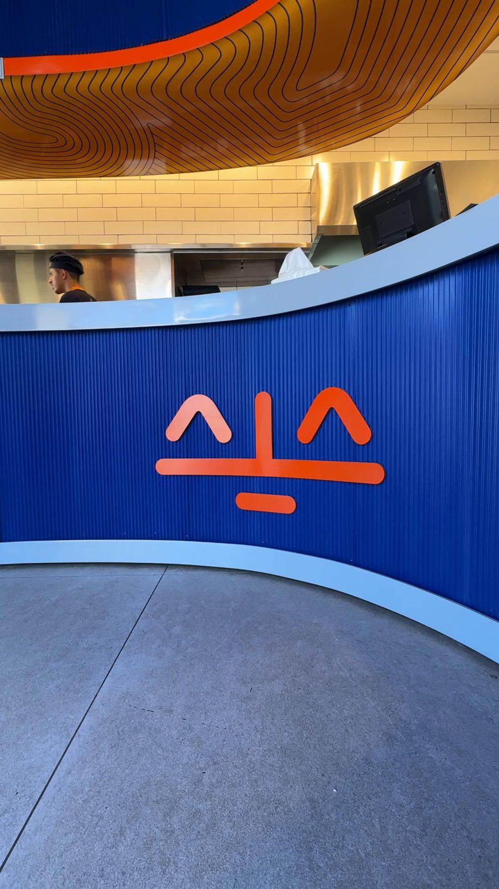 The curved blue counter with the restaurant's orange mark.